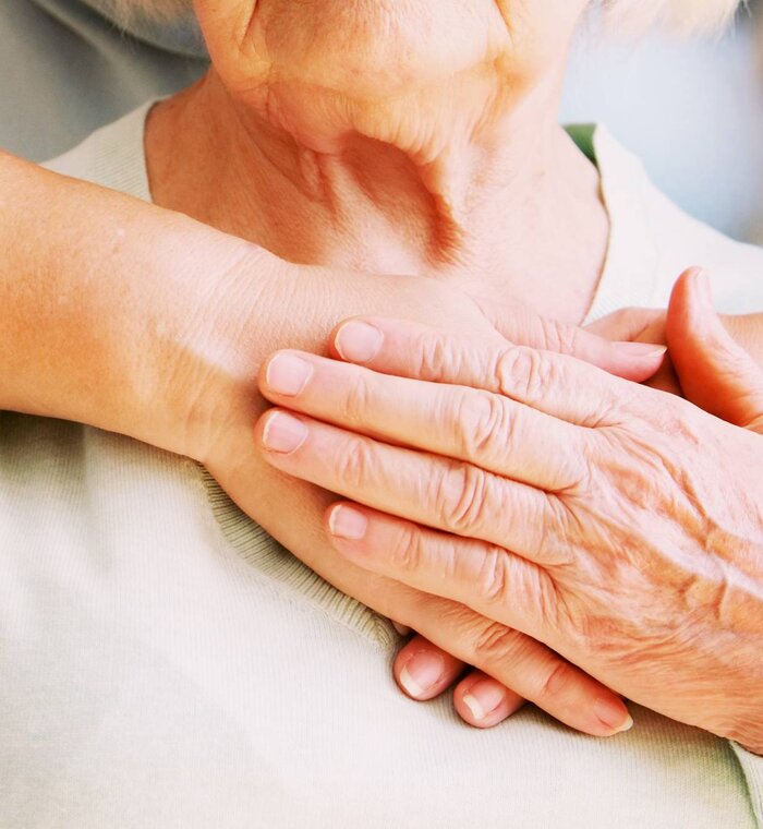 Ältere Frau in Altenpflegeeinrichtung erhält Hilfe vom Krankenhauspersonal.