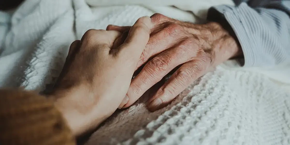 24-Stunden-Betreuerin hält Hand während der Nacht