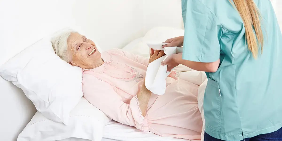 24-h-Betreuerin wäscht Seniorin